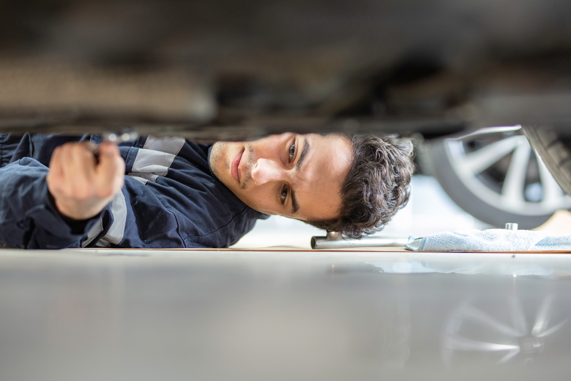 Young mechanic repairing a car